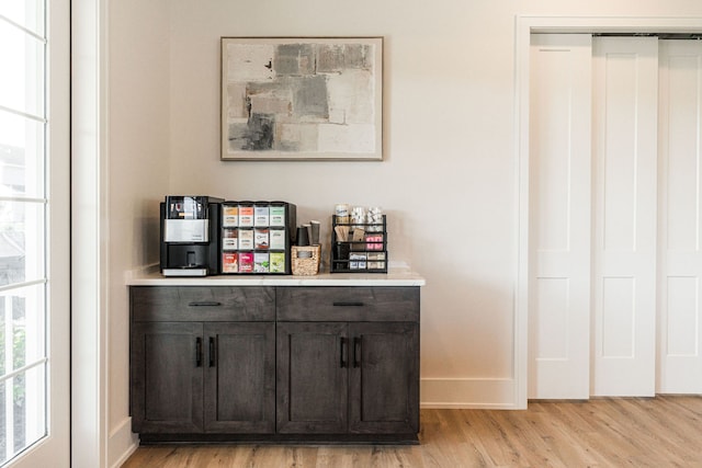 bar featuring dark brown cabinets and light wood-type flooring