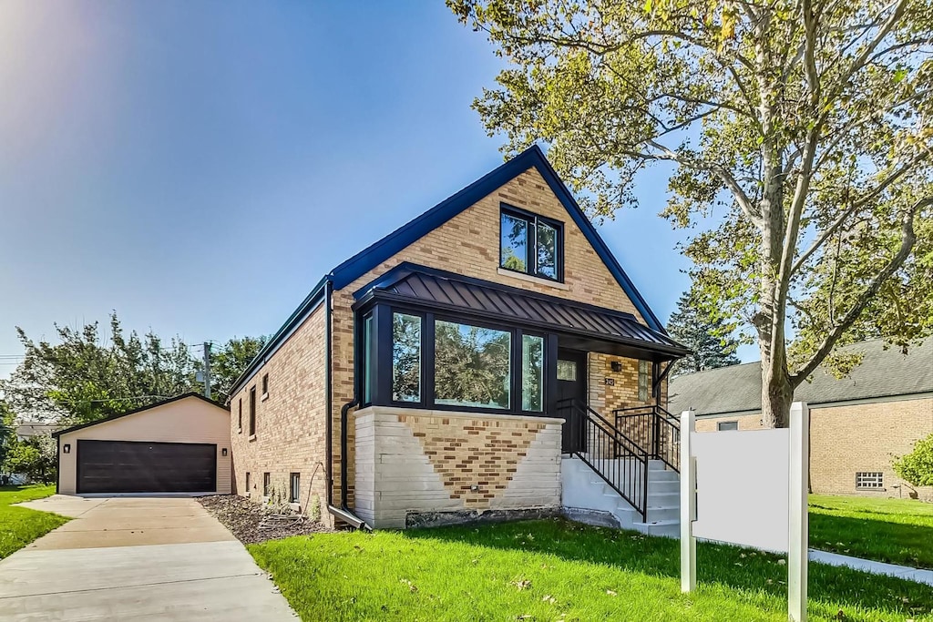 view of front of home featuring a front yard, an outdoor structure, and a garage