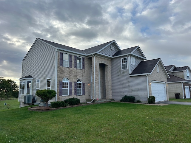 view of front of home featuring a front lawn, central AC, and a garage