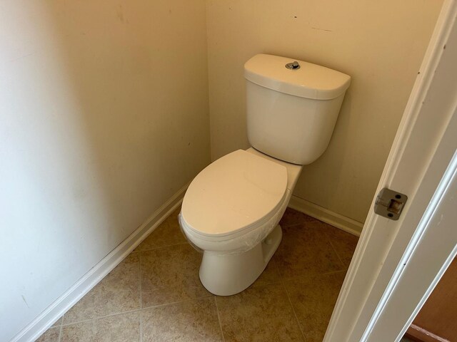 bathroom featuring  shower combination, toilet, and tile patterned floors