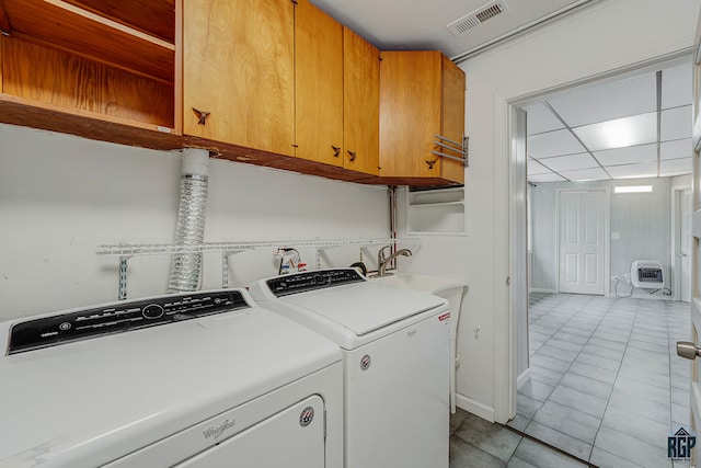 clothes washing area featuring separate washer and dryer, cabinets, heating unit, and light tile patterned floors