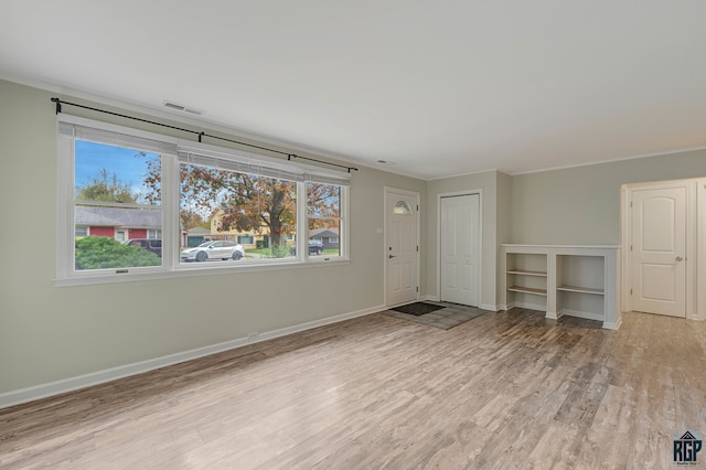 empty room featuring ornamental molding and light hardwood / wood-style floors