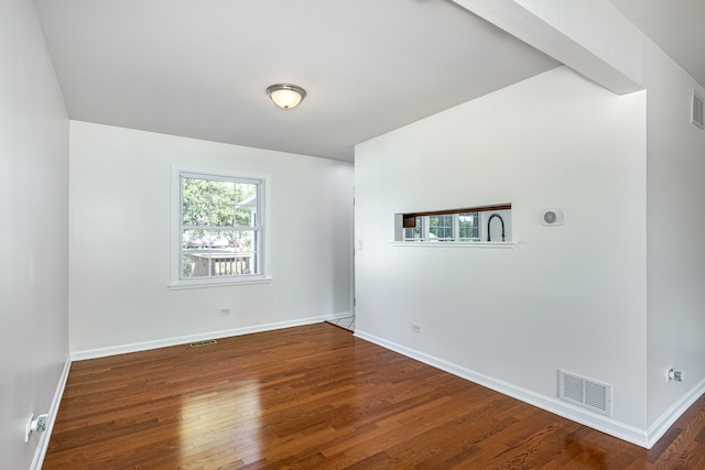 spare room featuring dark wood-type flooring