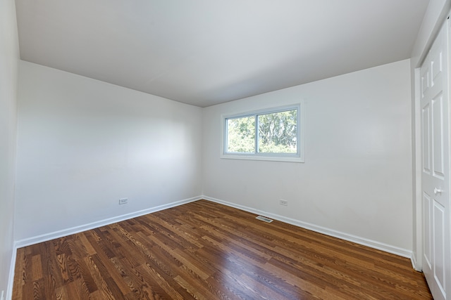 unfurnished room featuring dark wood-type flooring