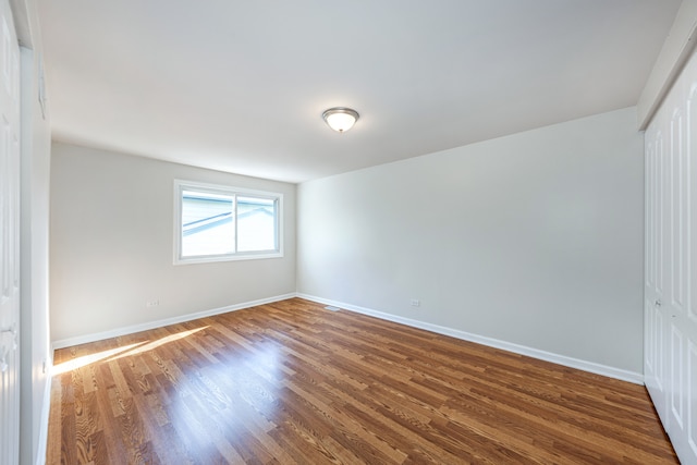 unfurnished room with dark hardwood / wood-style flooring