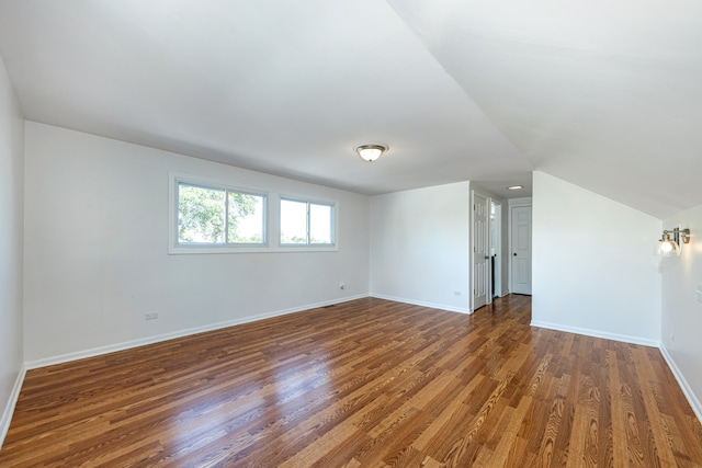 spare room with lofted ceiling and dark hardwood / wood-style flooring