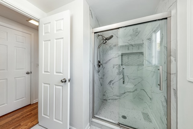 bathroom featuring wood-type flooring and walk in shower