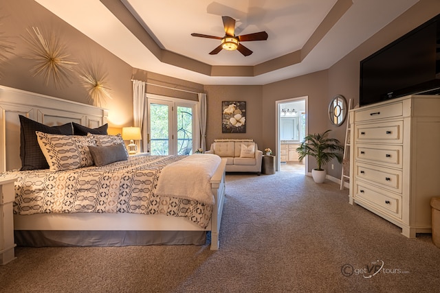 carpeted bedroom featuring ceiling fan, french doors, a tray ceiling, access to outside, and ensuite bathroom