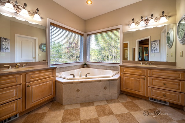 bathroom with vanity and tiled bath