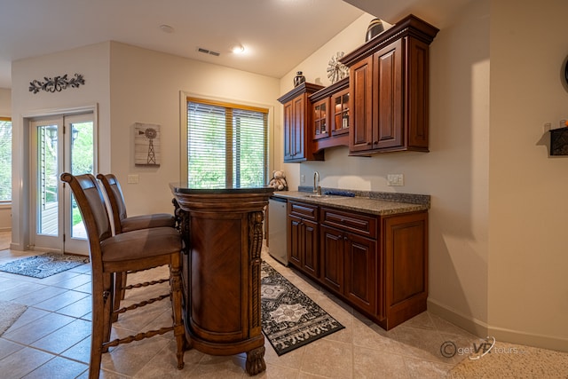 bar with dishwasher, sink, and light tile patterned floors