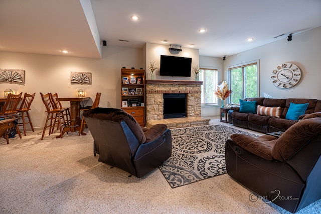 living room featuring light carpet and a stone fireplace