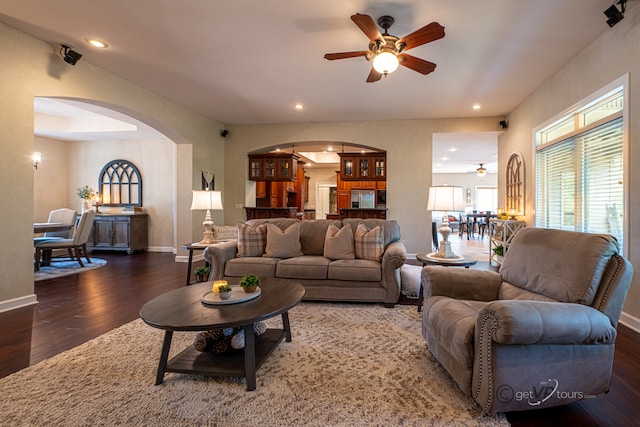 living room with ceiling fan and dark hardwood / wood-style flooring