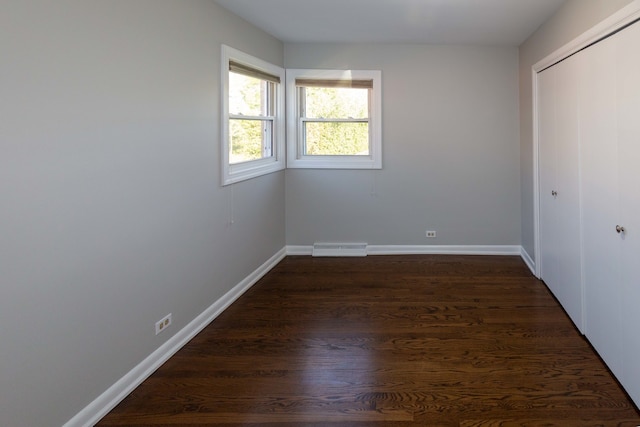 unfurnished bedroom with dark wood-type flooring