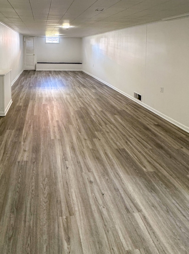 basement with dark hardwood / wood-style flooring