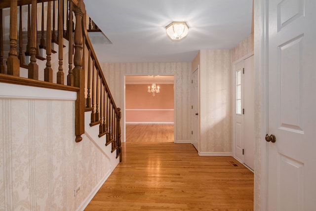 foyer with light hardwood / wood-style flooring and a notable chandelier