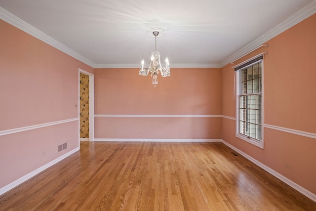 empty room with ornamental molding, a chandelier, and light hardwood / wood-style floors