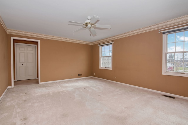 spare room featuring light carpet, plenty of natural light, crown molding, and ceiling fan