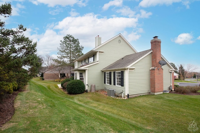 rear view of house featuring central AC and a yard