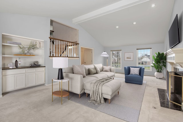 living room featuring a fireplace, beam ceiling, high vaulted ceiling, and light colored carpet