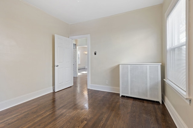 unfurnished bedroom featuring ornamental molding, radiator, and dark hardwood / wood-style flooring