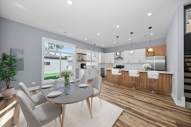 dining area featuring light wood-type flooring and sink