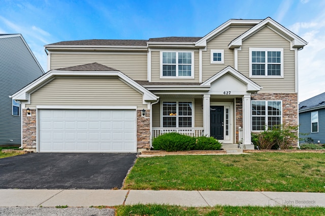 view of front of house featuring a garage, a porch, and a front lawn