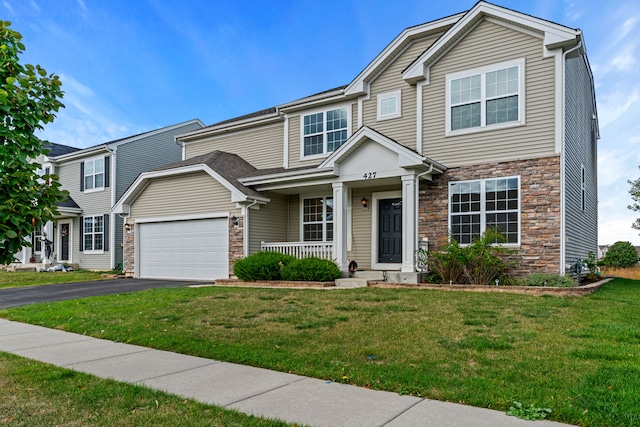 view of front of property with a garage, a porch, and a front lawn