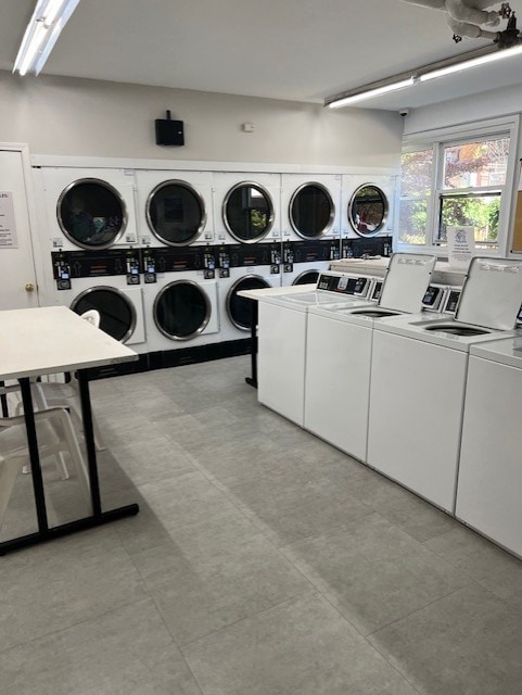 clothes washing area with washing machine and clothes dryer and stacked washer and dryer