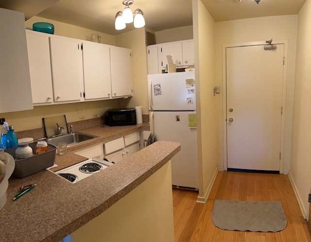 kitchen with kitchen peninsula, sink, white appliances, light hardwood / wood-style flooring, and white cabinetry