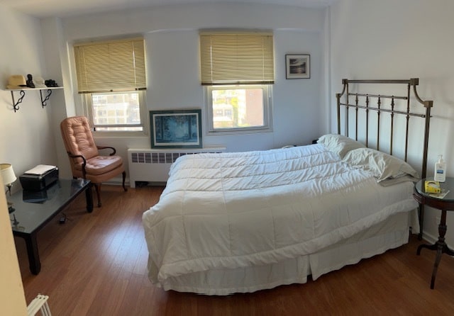 bedroom featuring radiator and hardwood / wood-style floors