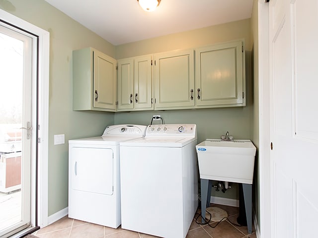 washroom featuring cabinets, sink, separate washer and dryer, and light tile patterned floors