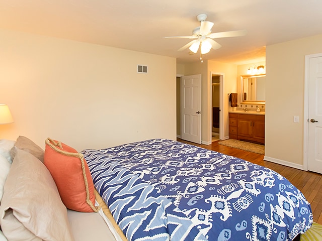 bedroom with ceiling fan, hardwood / wood-style flooring, and ensuite bathroom