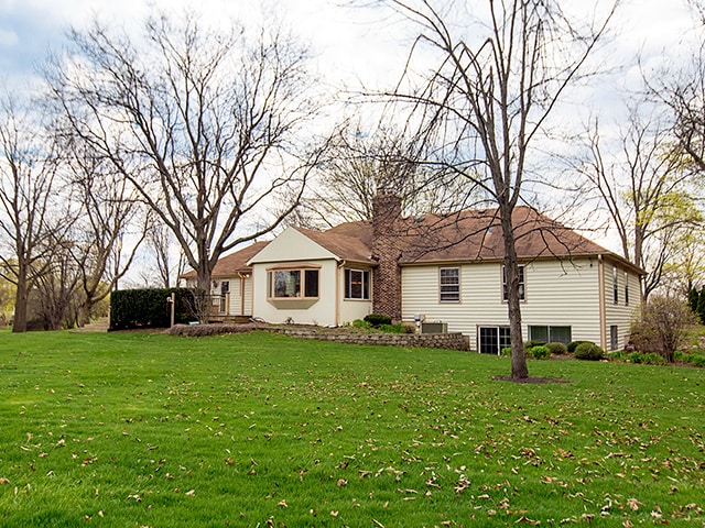 back of property featuring a lawn