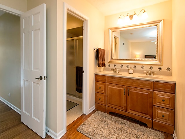 bathroom featuring a shower with door, vanity, and hardwood / wood-style flooring