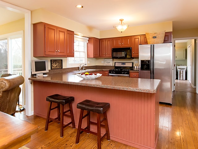 kitchen featuring a healthy amount of sunlight, sink, black appliances, and light hardwood / wood-style floors