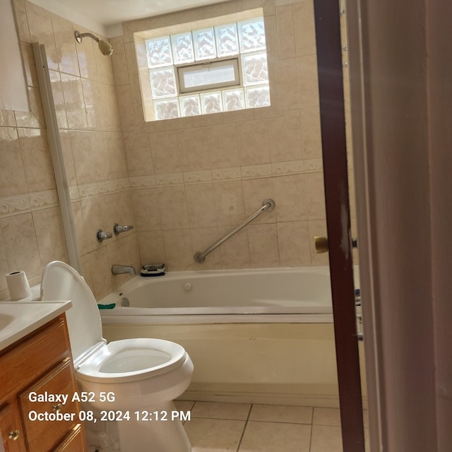 full bathroom featuring tiled shower / bath, vanity, toilet, and tile patterned floors