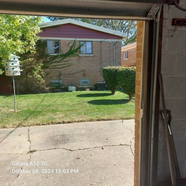 view of side of property with a patio area, central AC, and a lawn