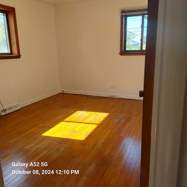 spare room featuring hardwood / wood-style floors and a wealth of natural light