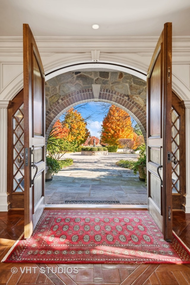 entryway with ornate columns and ornamental molding