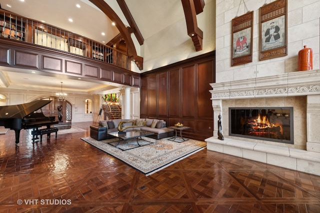 living room with decorative columns, a towering ceiling, ornamental molding, and parquet flooring