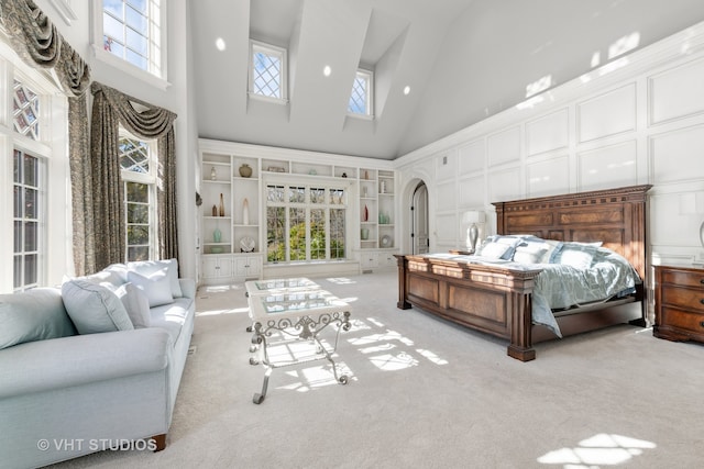 bedroom with light colored carpet and high vaulted ceiling