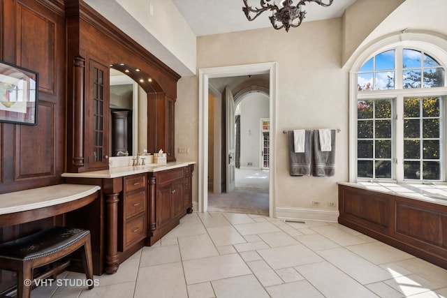 bathroom with tile patterned flooring, vanity, and a notable chandelier