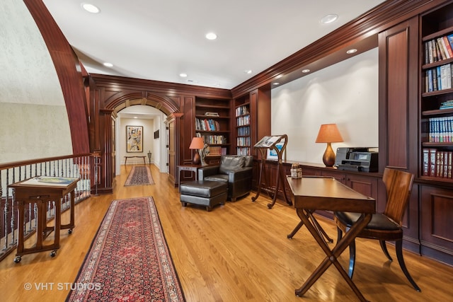 sitting room with built in features, light wood-type flooring, and crown molding