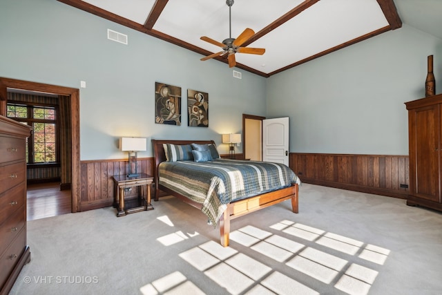 bedroom featuring wooden walls, ceiling fan, light carpet, and high vaulted ceiling