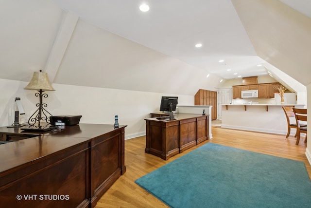 office area with light hardwood / wood-style flooring, vaulted ceiling, and sink