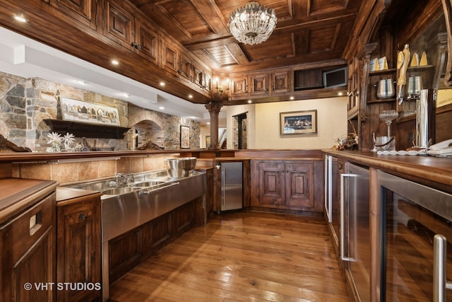 bar featuring light hardwood / wood-style floors, stainless steel refrigerator, wood ceiling, and beverage cooler