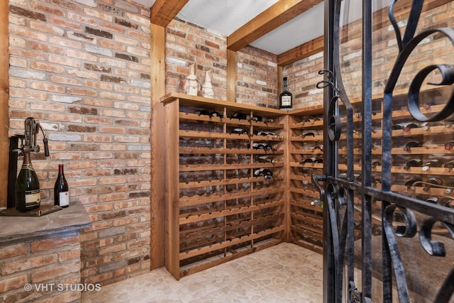 wine area with beamed ceiling and brick wall