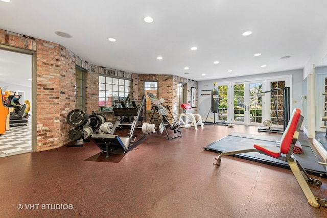 exercise area featuring french doors and brick wall