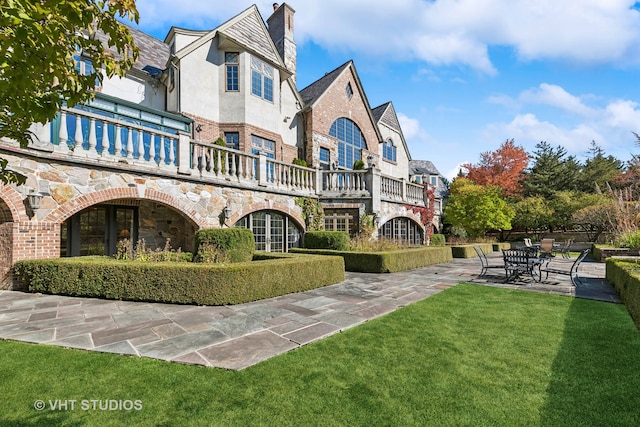 back of property featuring a yard and a patio