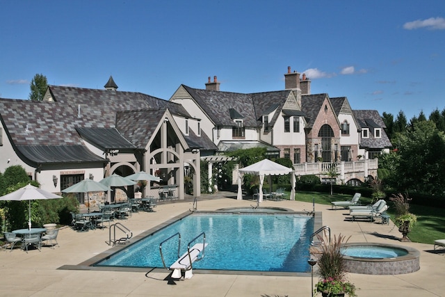 view of pool with a community hot tub and a patio area